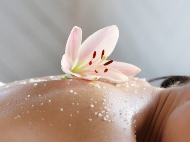 Femme allongée avec une fleur et du sel sur le dos